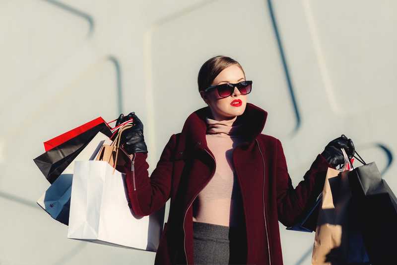 A woman showing off several shopping bags. I'm assuming she bought all of that using her splurge savings account