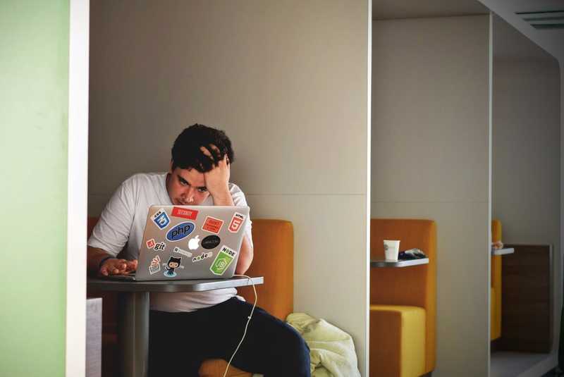 Some guy really stressed by whatever is on his computer screen