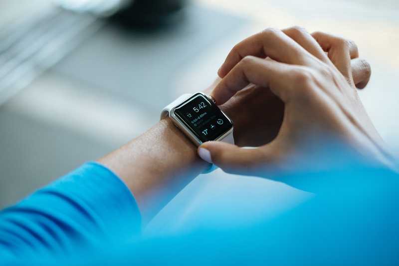 Guy checking his apple watch for the time as he realizes he late because he was picking stocks